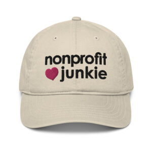 Oyster organic dad hat, black text on one side says nonprofit junkie in regular arial like font next to a pink heart