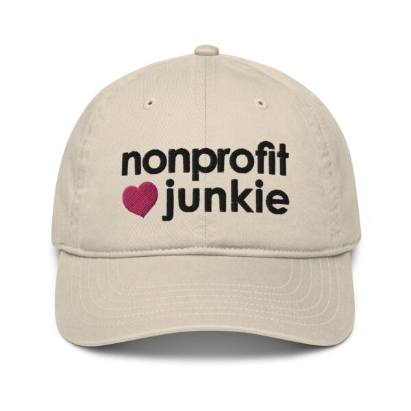 Oyster organic dad hat, black text on one side says nonprofit junkie in regular arial like font next to a pink heart