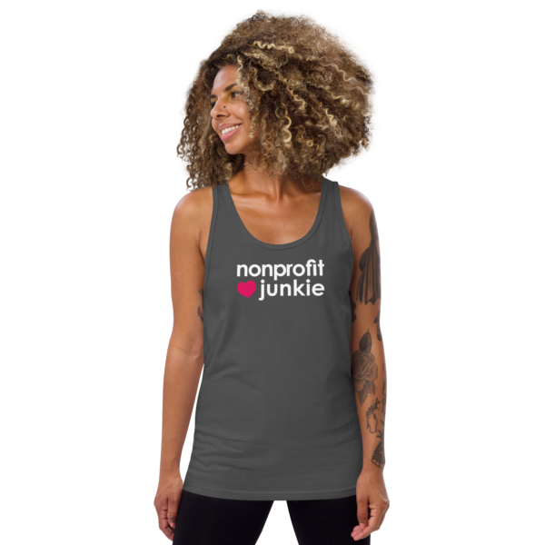 Unisex asphalt tank top, white text on one side says nonprofit junkie in regular arial like font next to a pink heart, on a woman