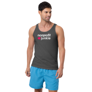 Unisex asphalt tank top, white text on one side says nonprofit junkie in regular arial like font next to a pink heart, on a man