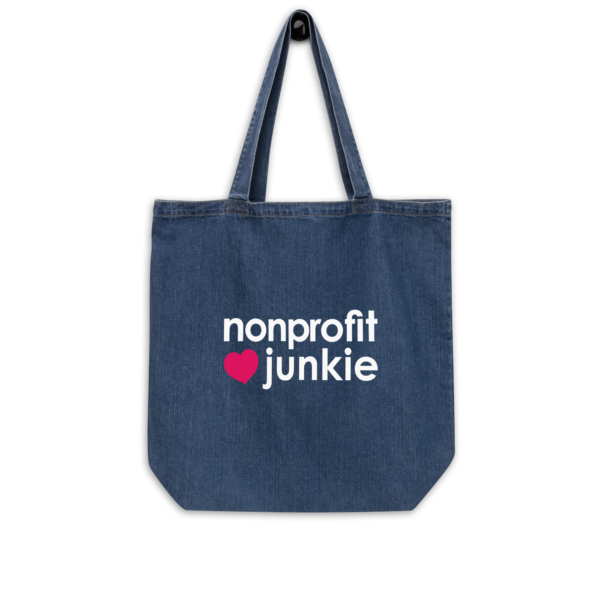 Organic denim tote bag, white text on one side says nonprofit junkie next to a pink heart