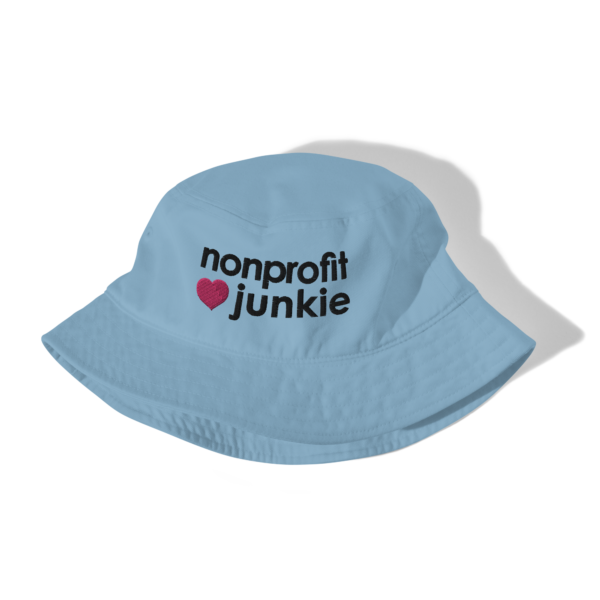 Slate blue bucket hat, black text on one side says nonprofit junkie in regular arial like font next to a pink heart