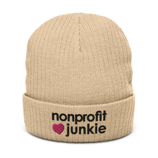 Beige ribbed knit beanie, black text on one side says nonprofit junkie in regular arial like font next to a pink heart