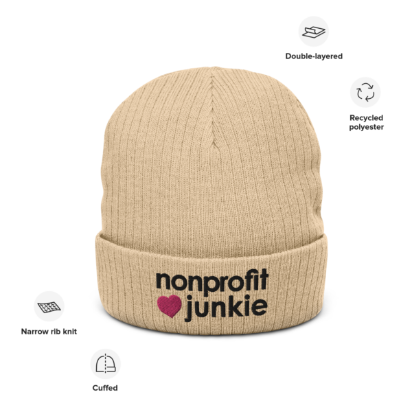 Beige ribbed knit beanie, black text on one side says nonprofit junkie in regular arial like font next to a pink heart