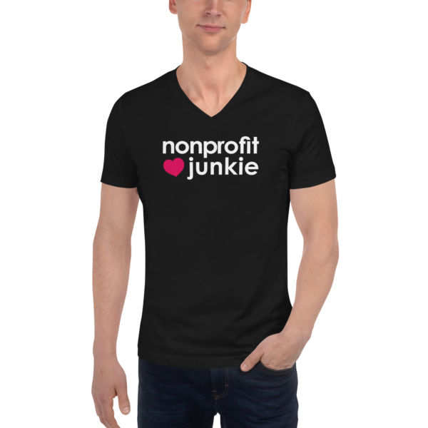 Unisex black v neck t shirt, white text on one side says nonprofit junkie in regular arial font next to a pink heart on a man