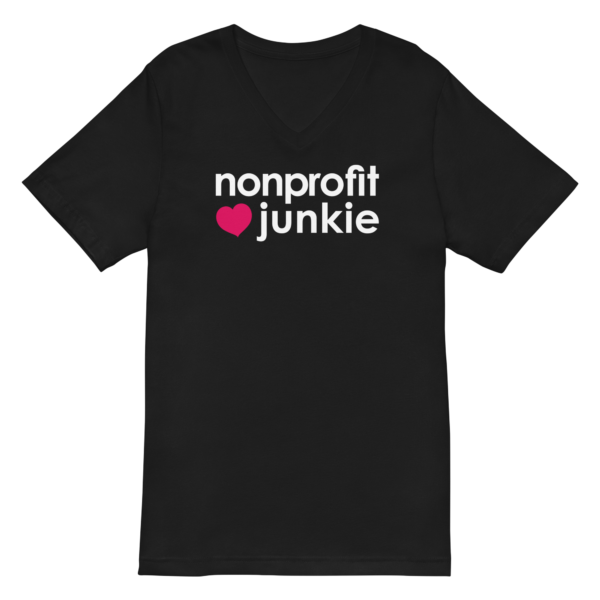 Unisex black v neck t shirt, white text on one side says nonprofit junkie in regular arial font next to a pink heart