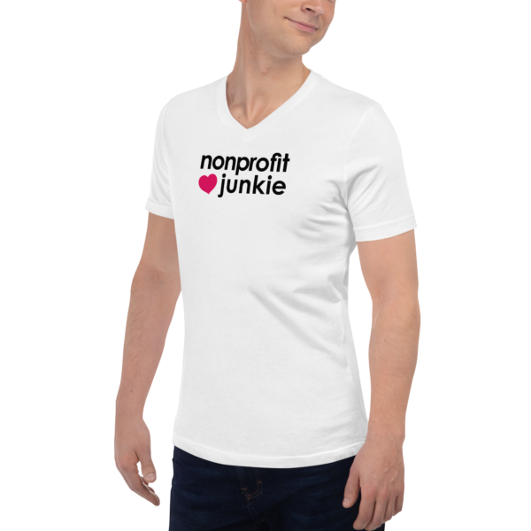 Unisex white v neck t shirt, black text on one side says nonprofit junkie in regular arial font next to a pink heart on a man