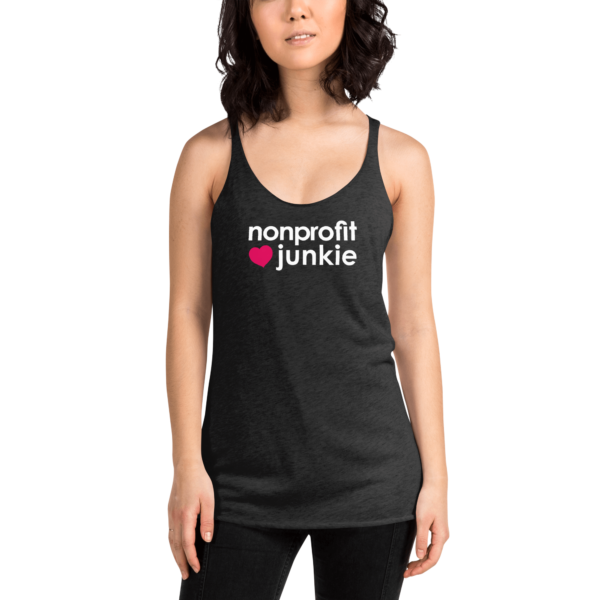 Womens vintage black racerback tank, white text on one side says nonprofit junkie next to a pink heart, on a woman