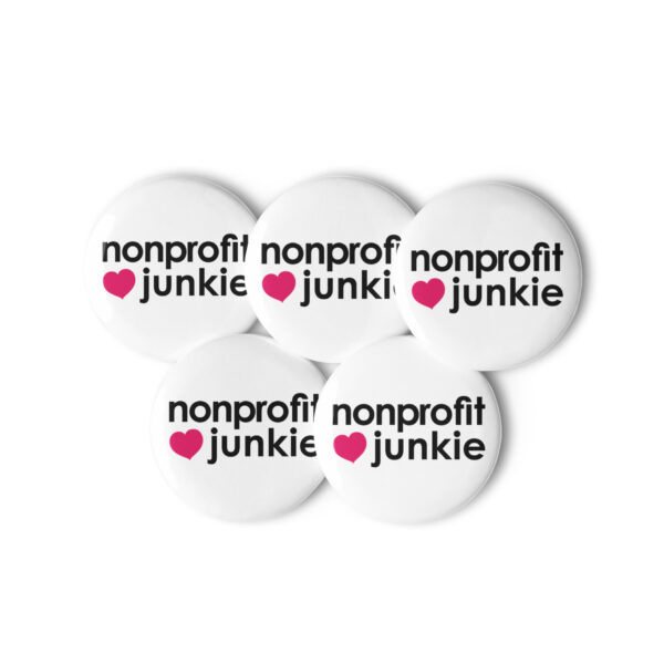 Set of white pin buttons, black text on one side says nonprofit junkie in regular arial like font next to a pink heart