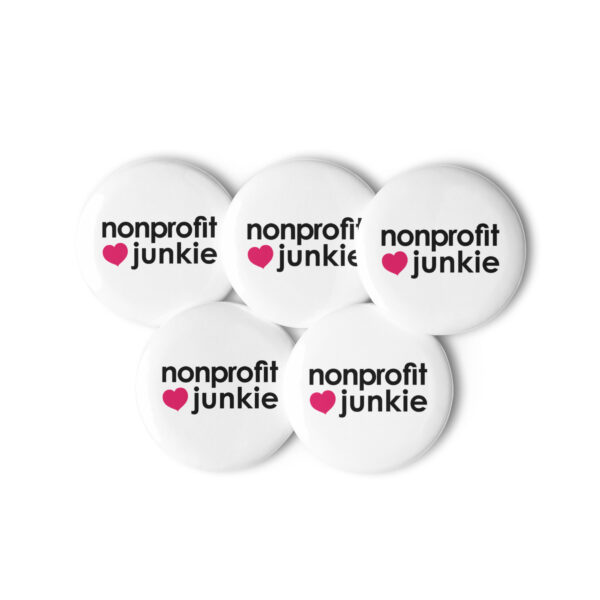 Set of white pin buttons, black text on one side says nonprofit junkie in regular arial like font next to a pink heart