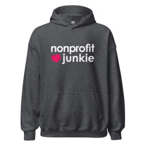 Unisex dark heather hoodie, white text on one side says nonprofit junkie in regular arial like font next to a pink heart