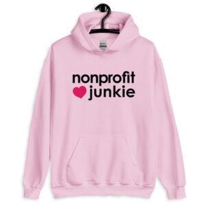 Unisex light pink hoodie, black text on one side says nonprofit junkie in regular arial like font next to a pink heart