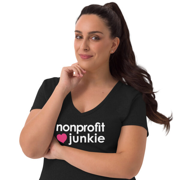 Womens black recycled v neck t shirt, white text on one side says nonprofit junkie in regular arial font next to a pink heart on a woman