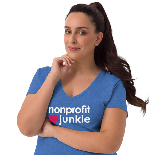 Womens heather blue recycled v neck t shirt, white text on one side says nonprofit junkie in regular arial font next to a pink heart on a woman