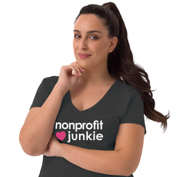 Womens charcoal heather recycled v neck t shirt, white text on one side says nonprofit junkie in regular arial font next to a pink heart on a woman