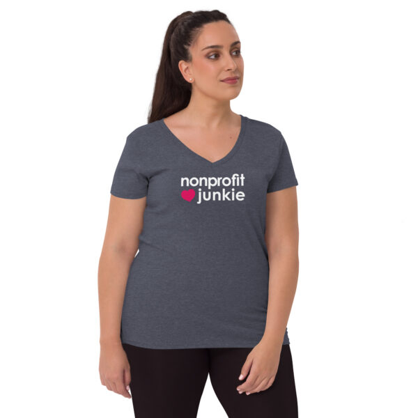 Womens heather navy recycled v neck t shirt, white text on one side says nonprofit junkie in regular arial font next to a pink heart on a woman